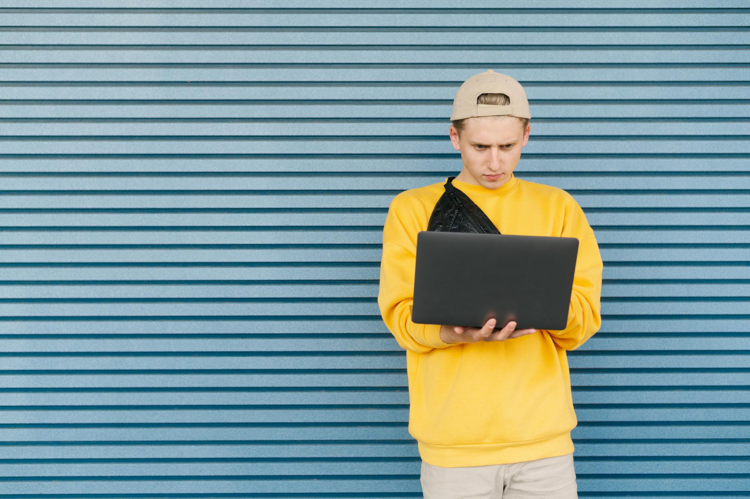 guy in a yellow sweater with a laptop